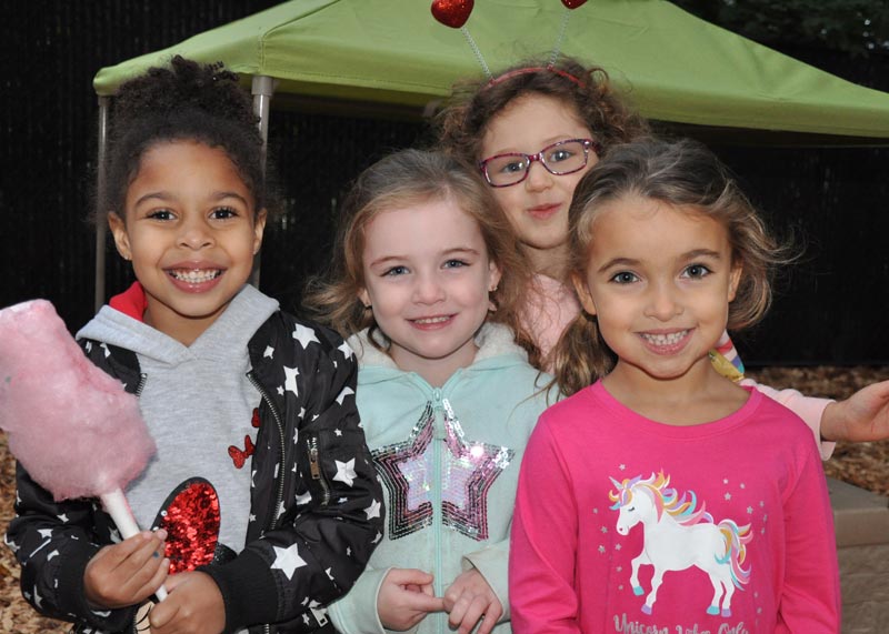 Group of 4 girls smiling while at a special school event with cotton candy