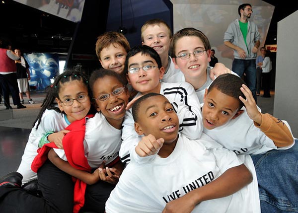 diverse group of afterschool students smiling and posing for photo