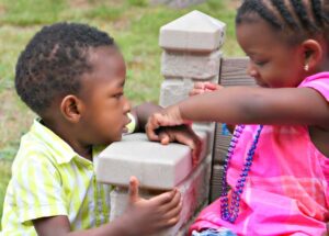 toddler boy and girl on a bench talking