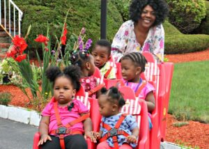 Caregiver pushing 5 kids in a jump stroller