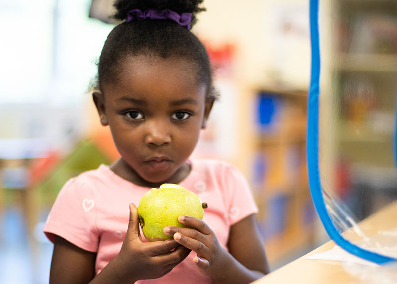 RPS-replacement-2 Toddler Black girl eating an apple, very serious face